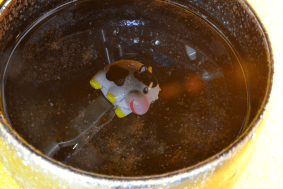 湯呑みの水面に映った牛の人形